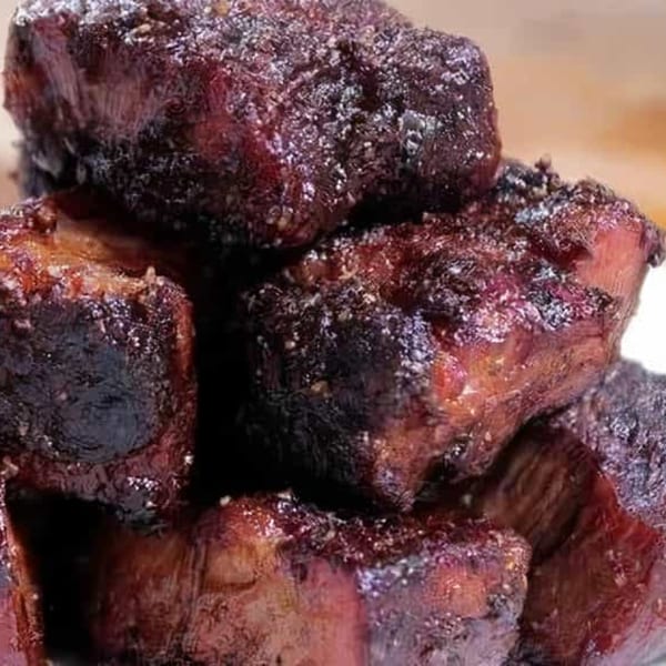 Close-up of a pile of dark, glistening BBQ burnt ends from Larry J's BBQ Cafe.